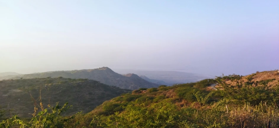 the landscape of a hilly area with several mountains and greenery