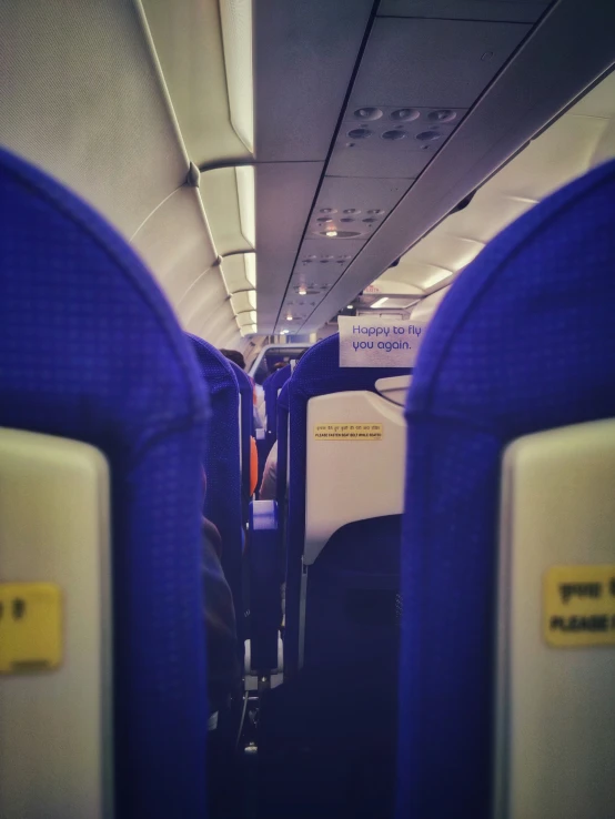 the interior of a airplane showing several blue seats