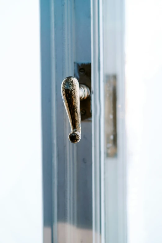 a metal handle on a door with glass