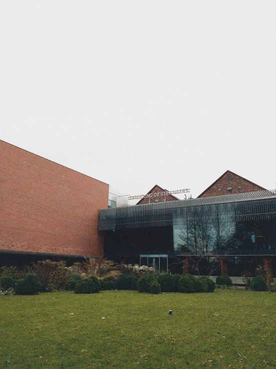 an outdoor area with grass and buildings that are brick