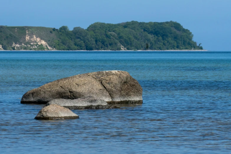 a rock sits in the middle of the water