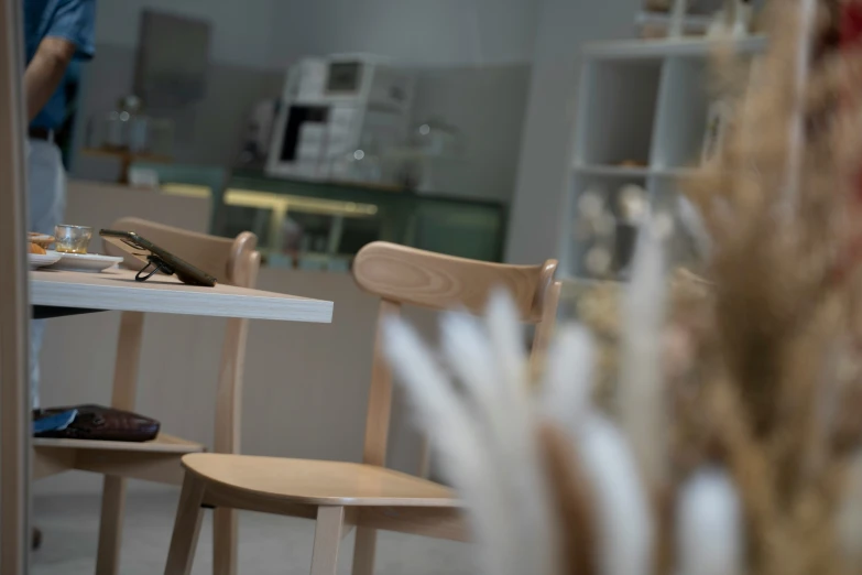 a person sitting at a table with a cell phone in hand