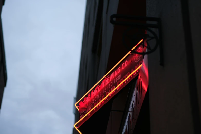 a sign hanging on a building with red light above