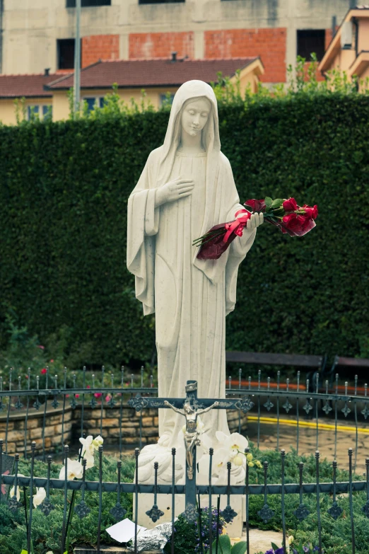 a white statue with a bouquet of roses on it