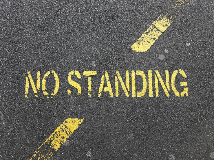 a no standing arrow painted on a road