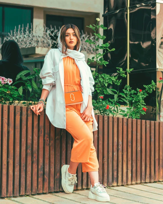 a woman leaning on a fence leaning against it