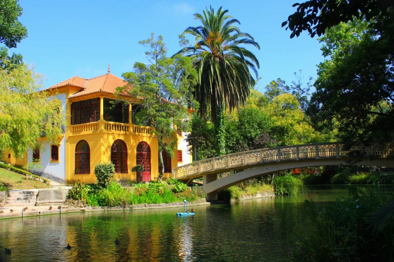 the water has green vegetation growing beside it, and a bridge is over it