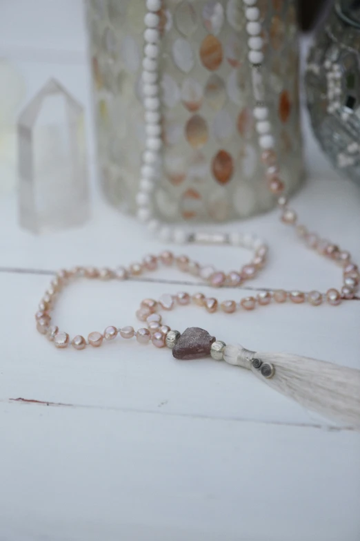 a white pearl necklace with a tassel hanging from it