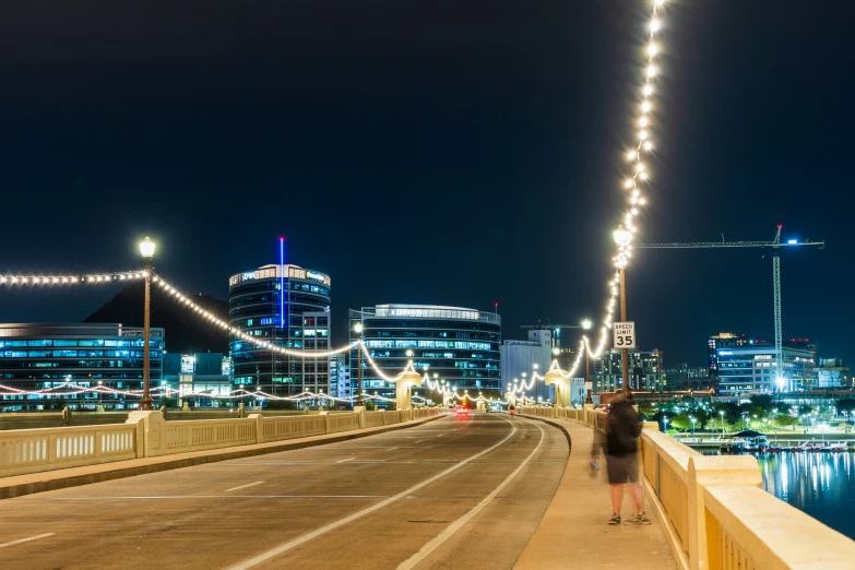 the bridge across the river has lights all over it