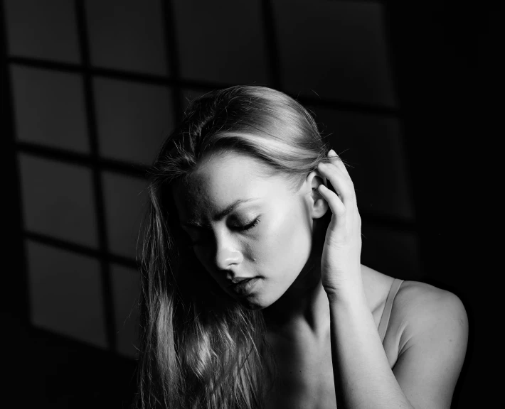 a young woman is clutching her hair while she looks down