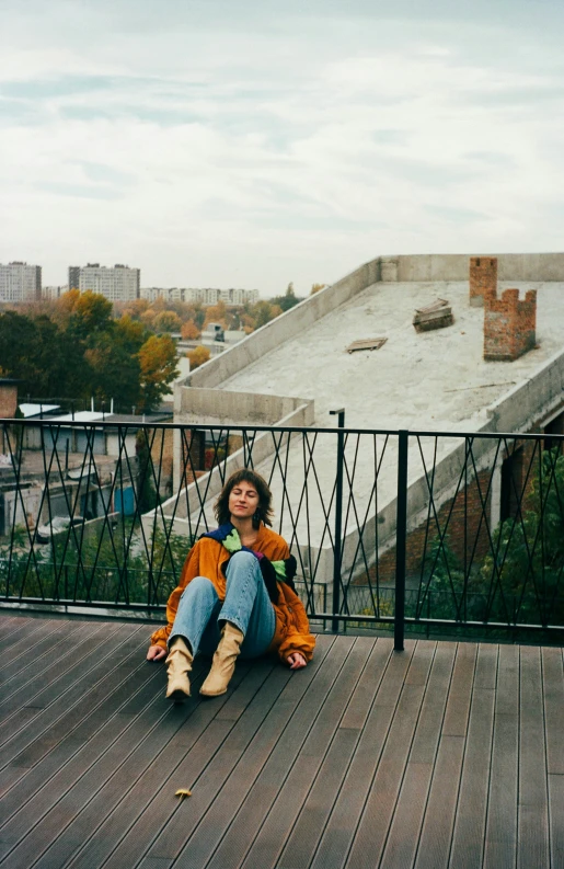 a woman sitting on the side of a wooden deck