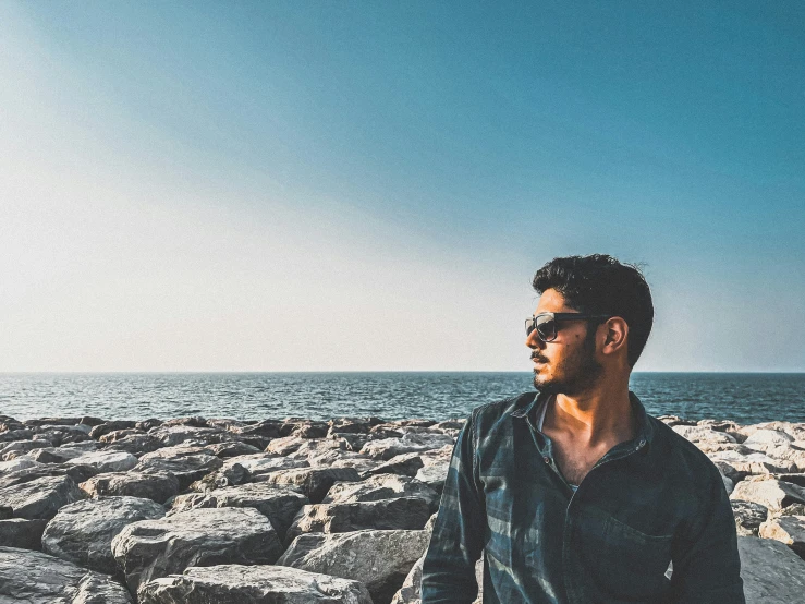 man walking down stone path to the ocean