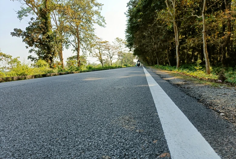 an asphalt road that has white painted stripes in the middle