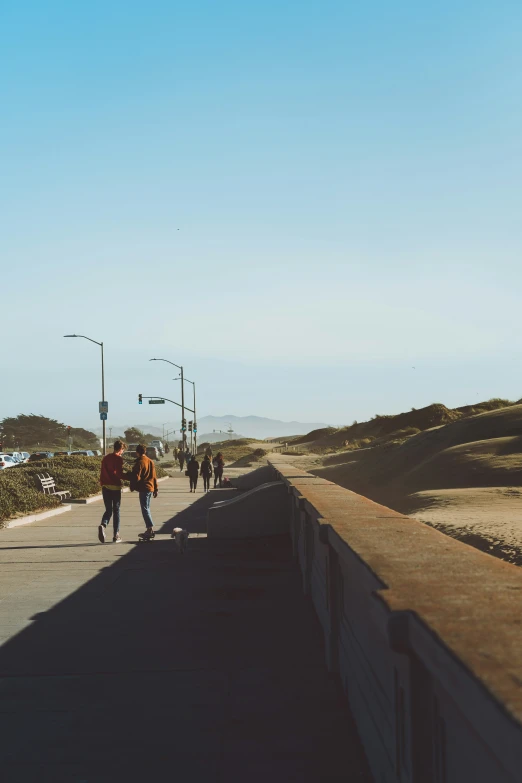 people walking on a sidewalk that has a sky line