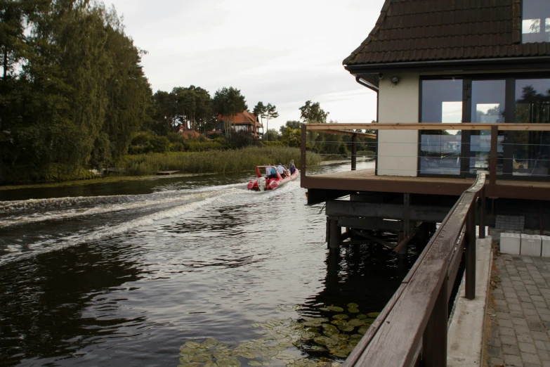 a group of people are on a boat that is approaching a house