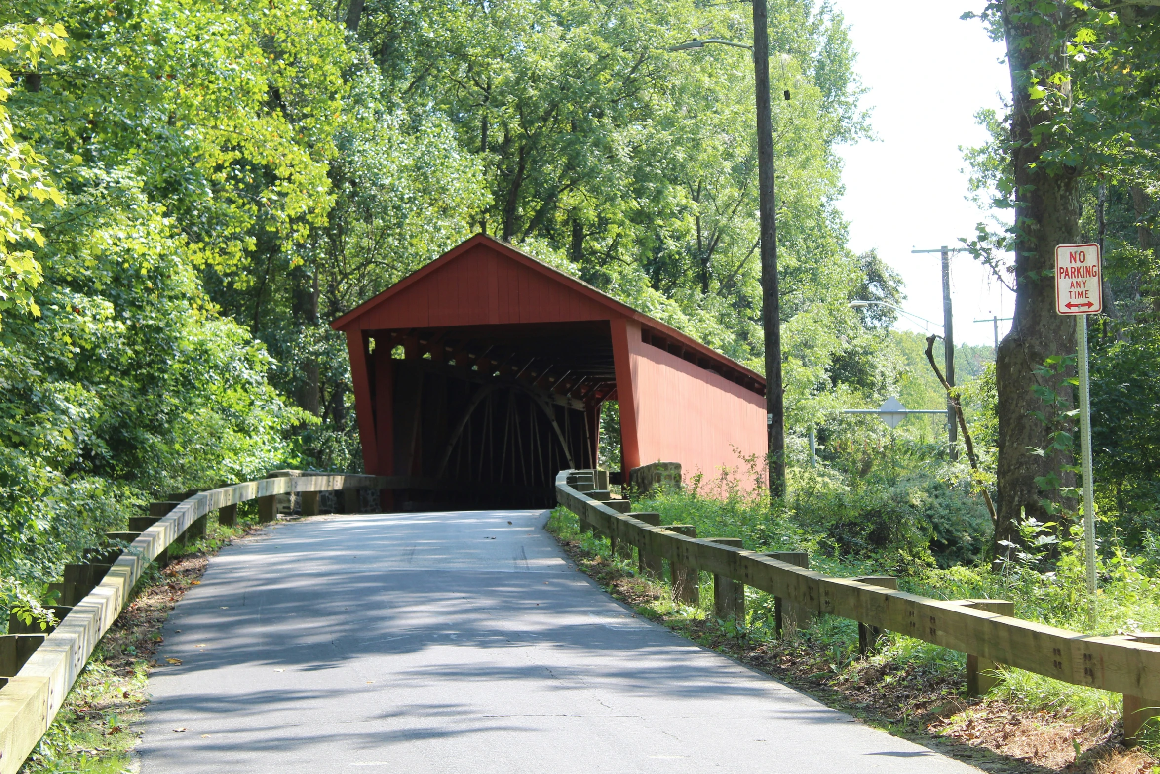 a red covered bridge crossing an empty road