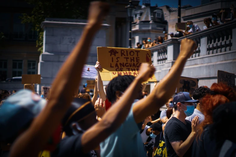 a crowd of people with protest signs in their hands