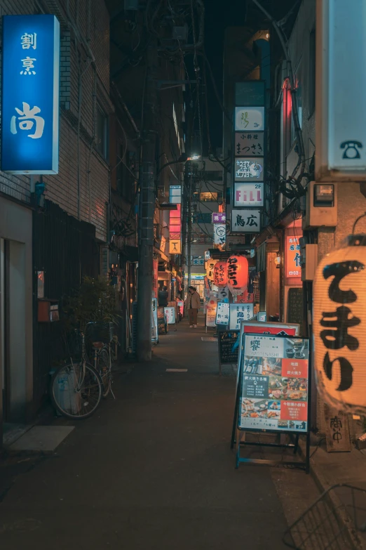 a narrow alley between two buildings and neon signs