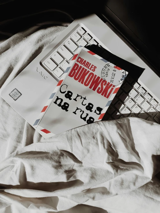 a book sitting on top of an unmade keyboard