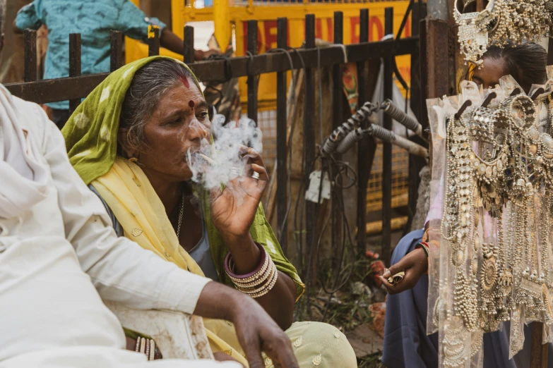 a woman smoking a cigarette as two others watch