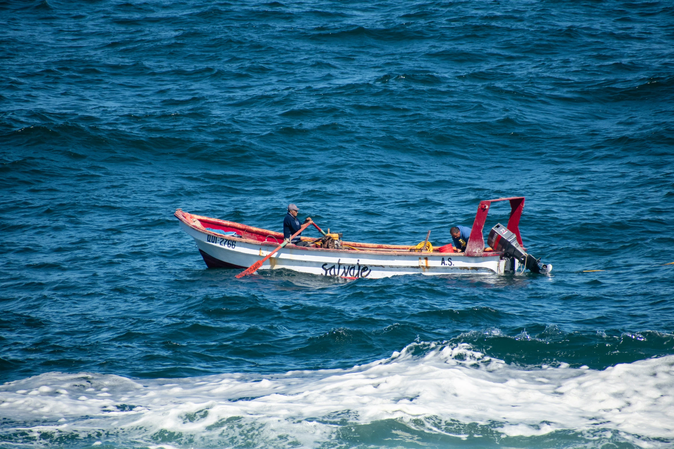 two people are sitting in a small white boat