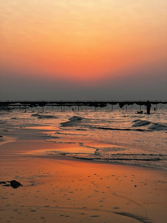 several people walk on the water at sunset