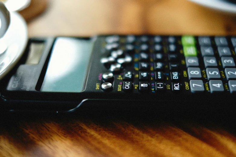 a cell phone sitting on top of a wooden desk