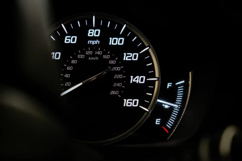 a car dashboard with lights and gauges in the darkness