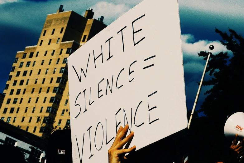 a group of people are holding up a white sign