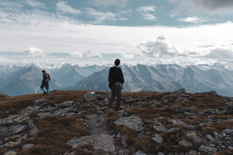 two men stand on the top of a mountain