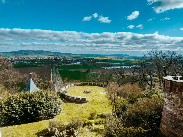 an outdoor view shows a field, river and buildings