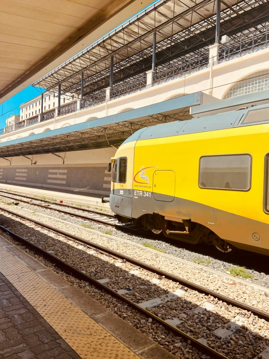 yellow and grey passenger train parked at a station