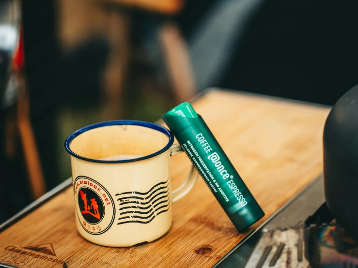 a coffee cup is on a counter next to a tube of toothpaste