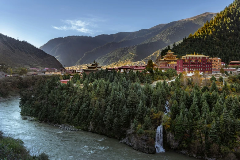 small mountain village next to river with buildings in the distance