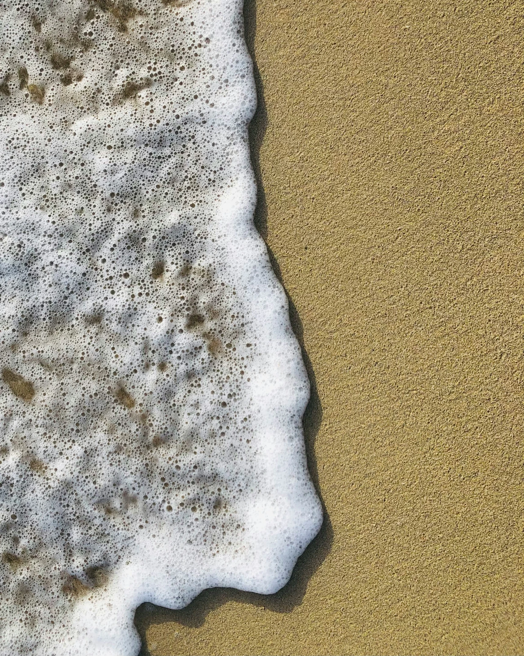 water is foamy by itself and the sand is brown