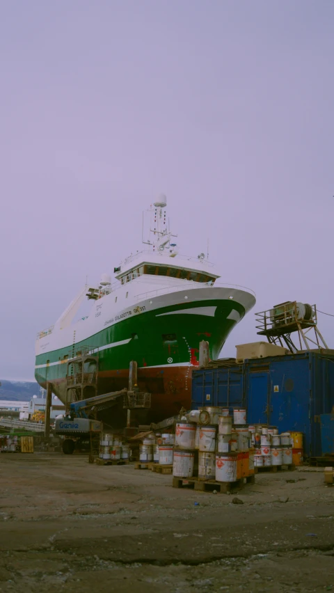 large boat being unloaded by cranes on concrete ground