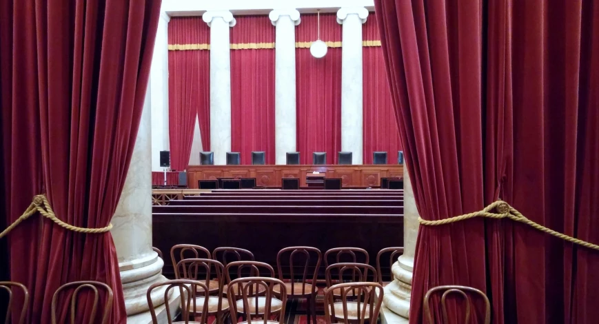 red ds in a courtroom with chairs and a table