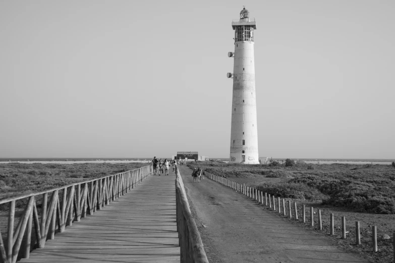 some people walk across a bridge to go to the lighthouse