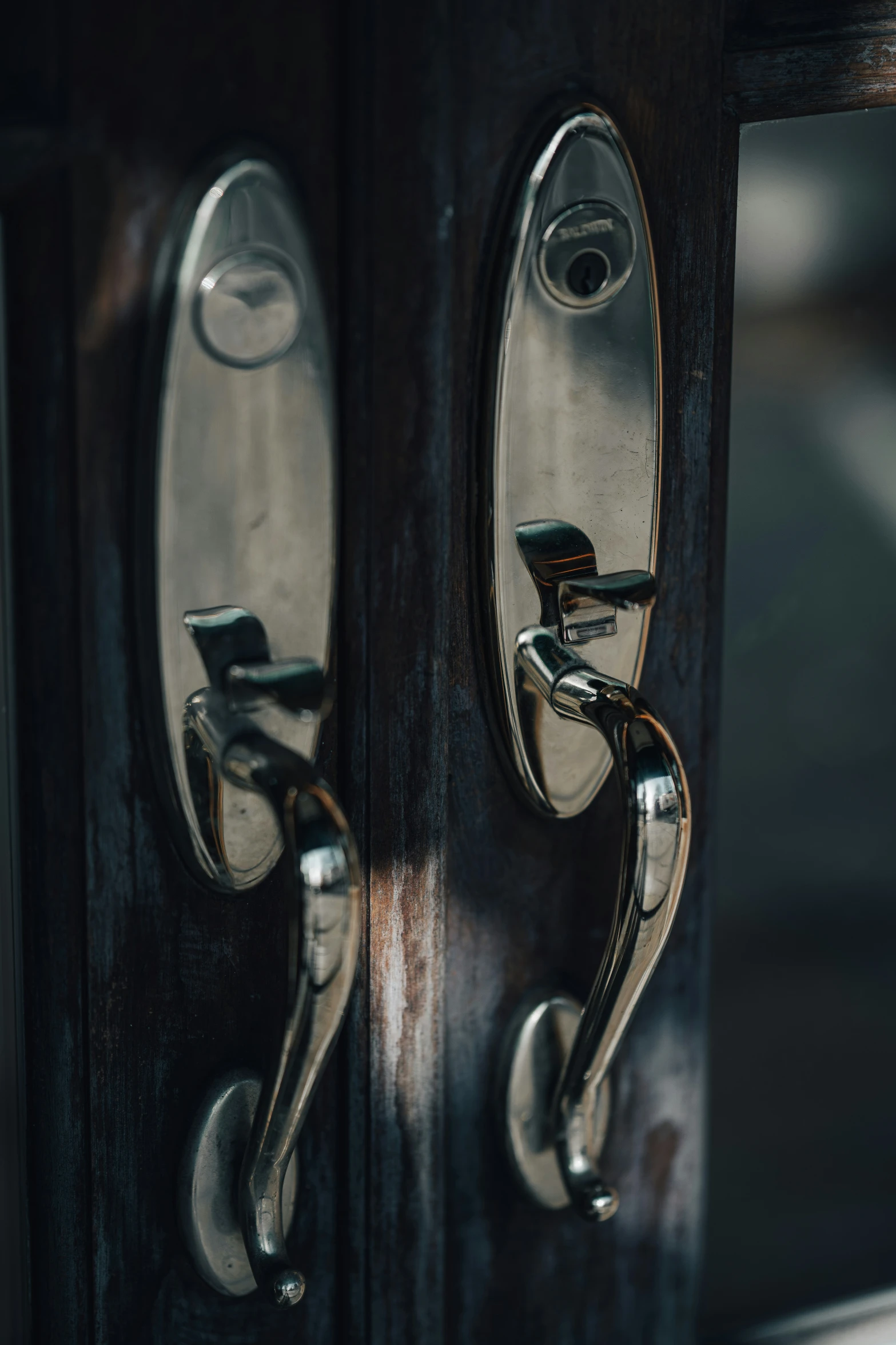 a pair of handle handles on the door of an old, weathered looking wooden building