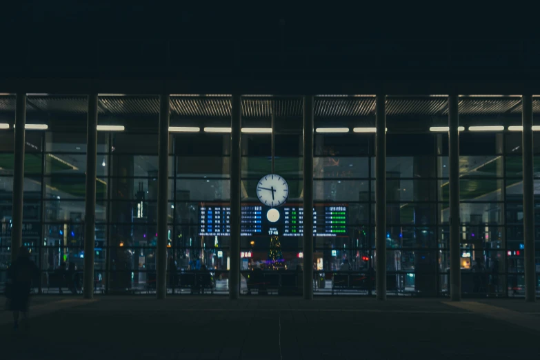 a clock on the front of a building is lit up at night