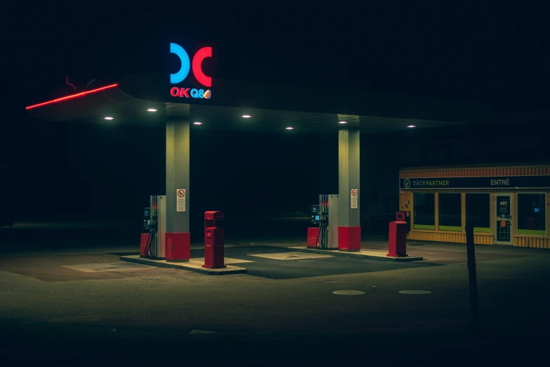 three lit up gas pumps at night time