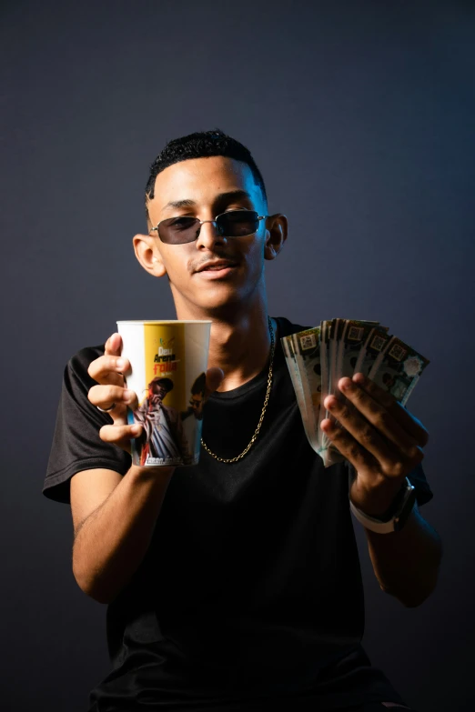 man with sunglasses holding two coffee mugs and playing card games
