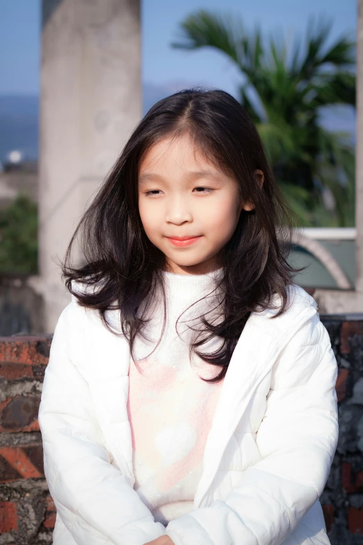 a  standing outside wearing a white coat