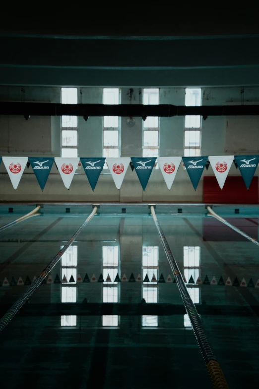 a man swimming in a pool next to windows