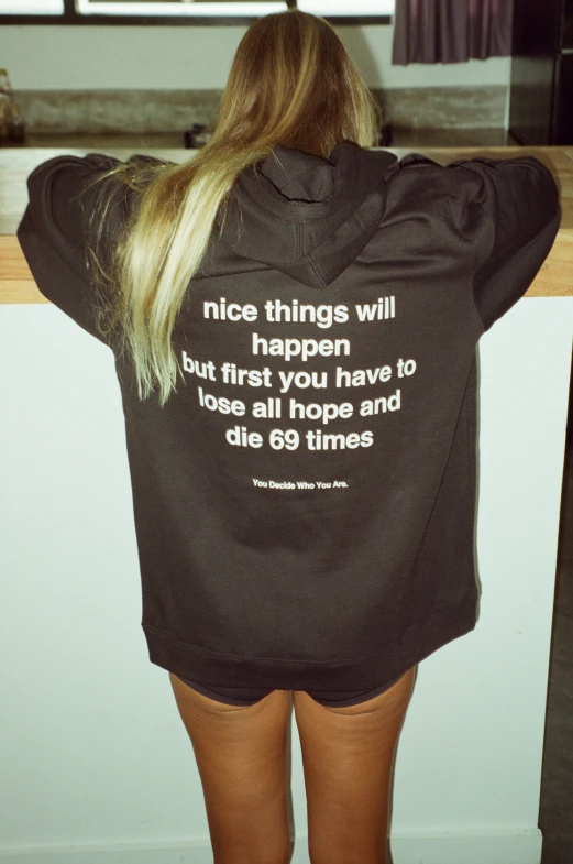 a woman is wearing a sweatshirt with words on it