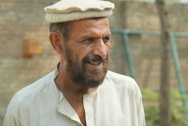 an older man wearing a white cap on his head