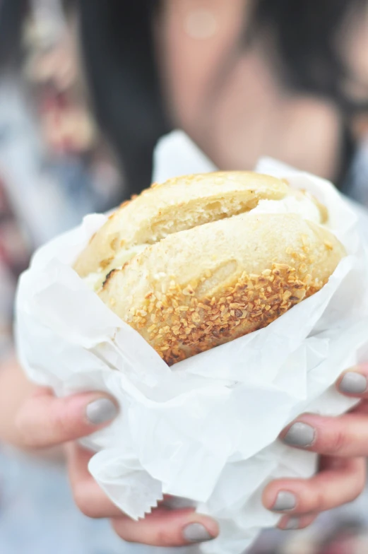 two people are holding a sandwich on a white paper