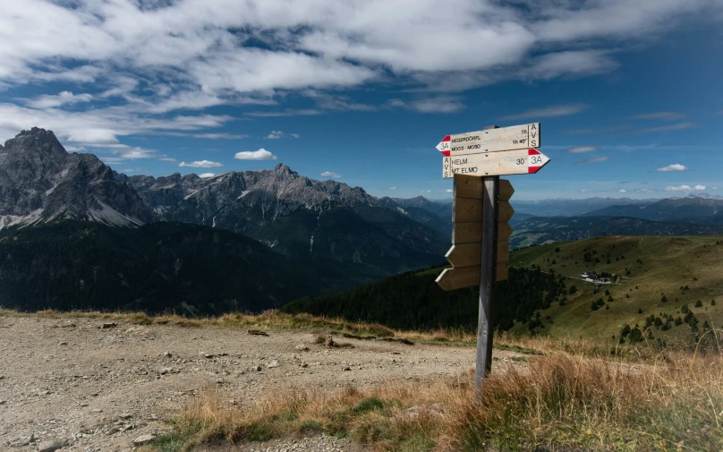 the view of a mountain top with a directional sign