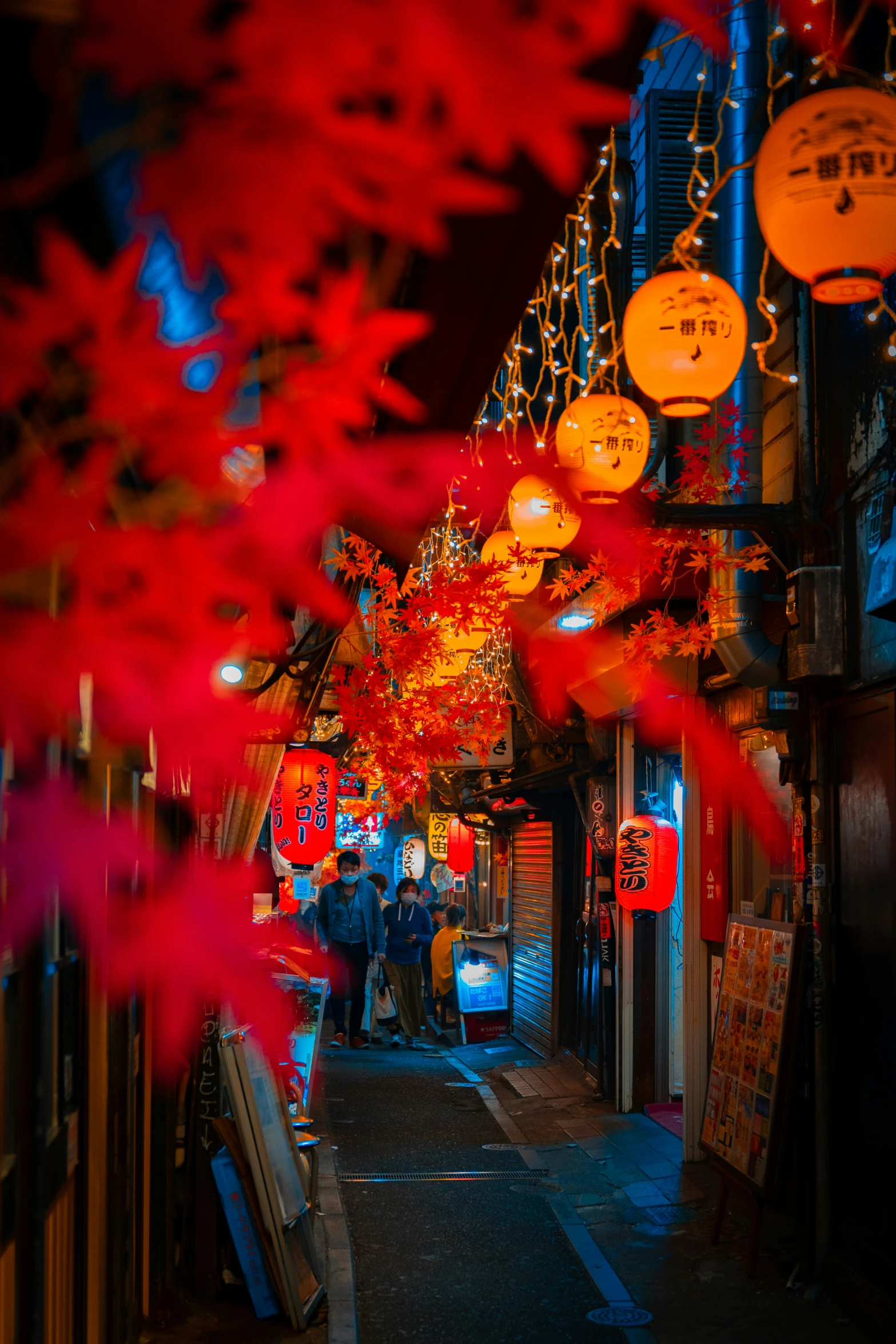 a narrow road covered in lanterns and lights