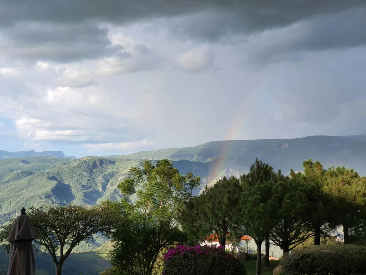 the view from the back of a house overlooking a hillside and rainbow